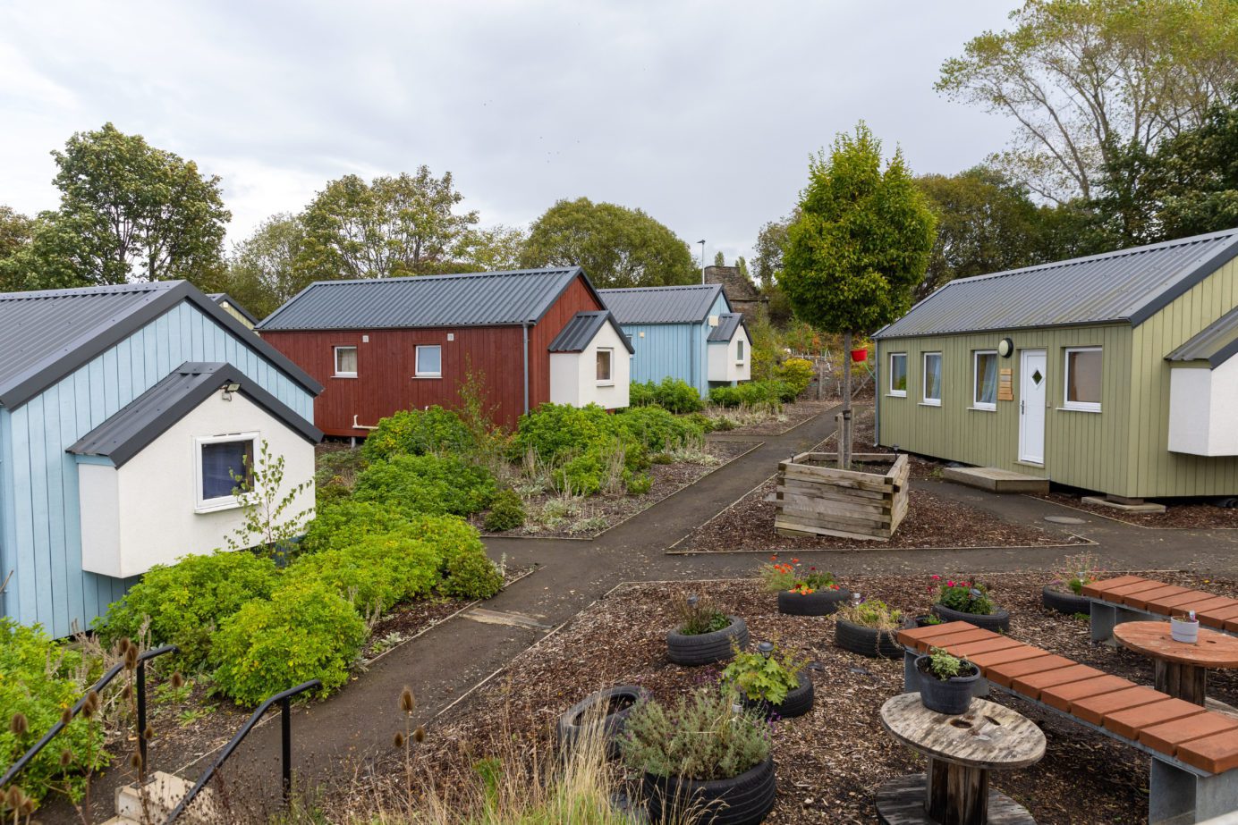 Small houses painted in different colours around a garden