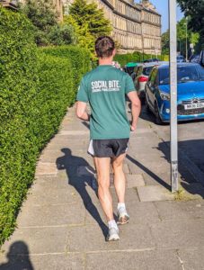 A man in a green tshirt runs away from the camera